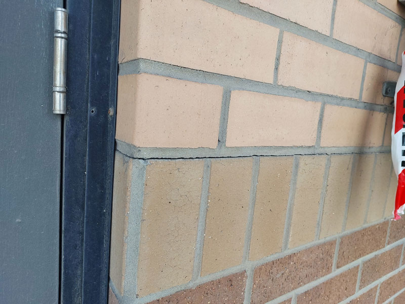 Horizontal cracking along mortar joints in masonry walls caused by seismic movement.
