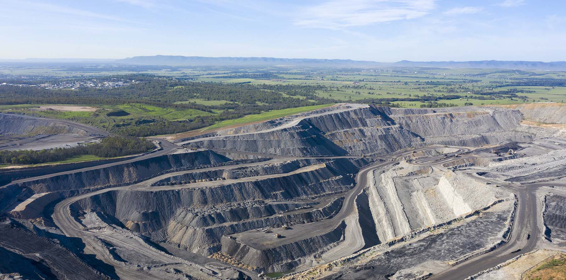 Open-cut mining operation in the Hunter Valley region of New South Wales, showing terraced excavation and haul roads.
