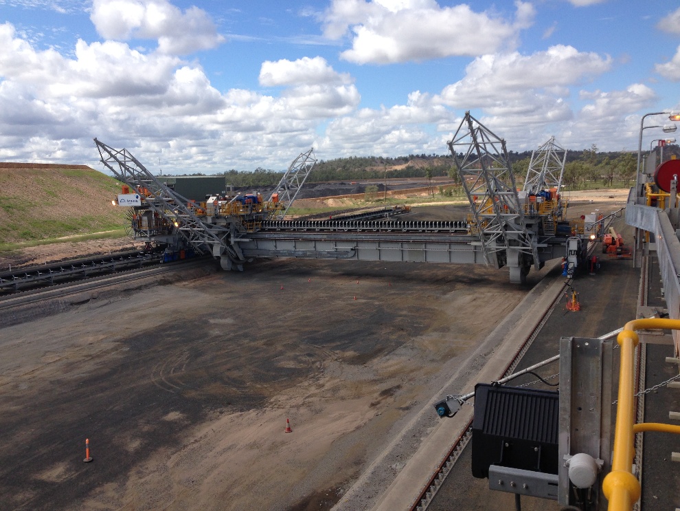 Bridge reclaimer spanning a stockpile area with bucketwheel reclaiming equipment at a bulk materials facility.