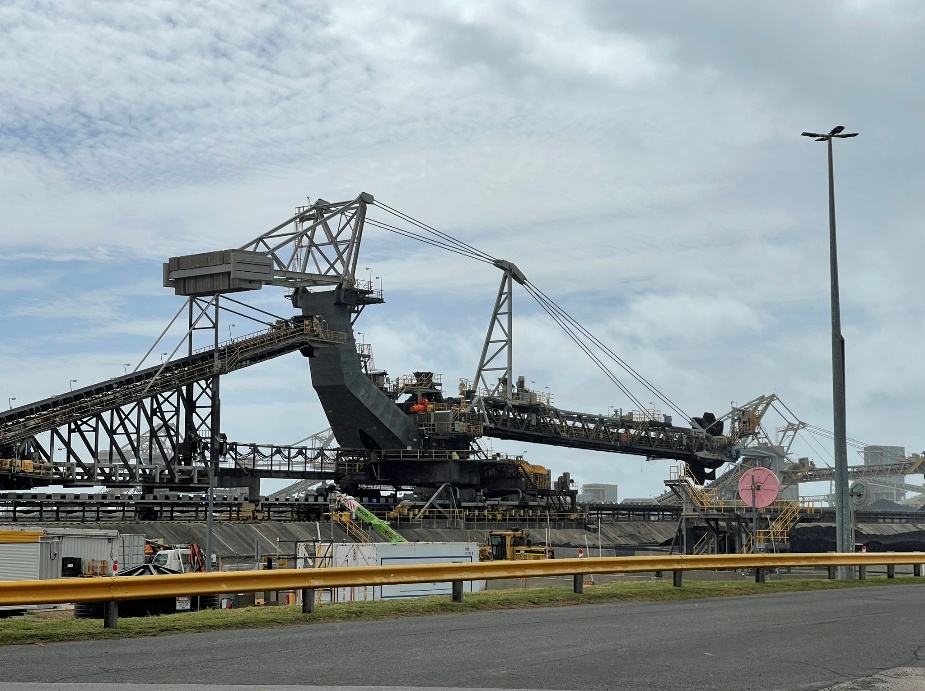 J frame stacker reclaimer showing the articulated boom, counterweight and rail-mounted machine structure.