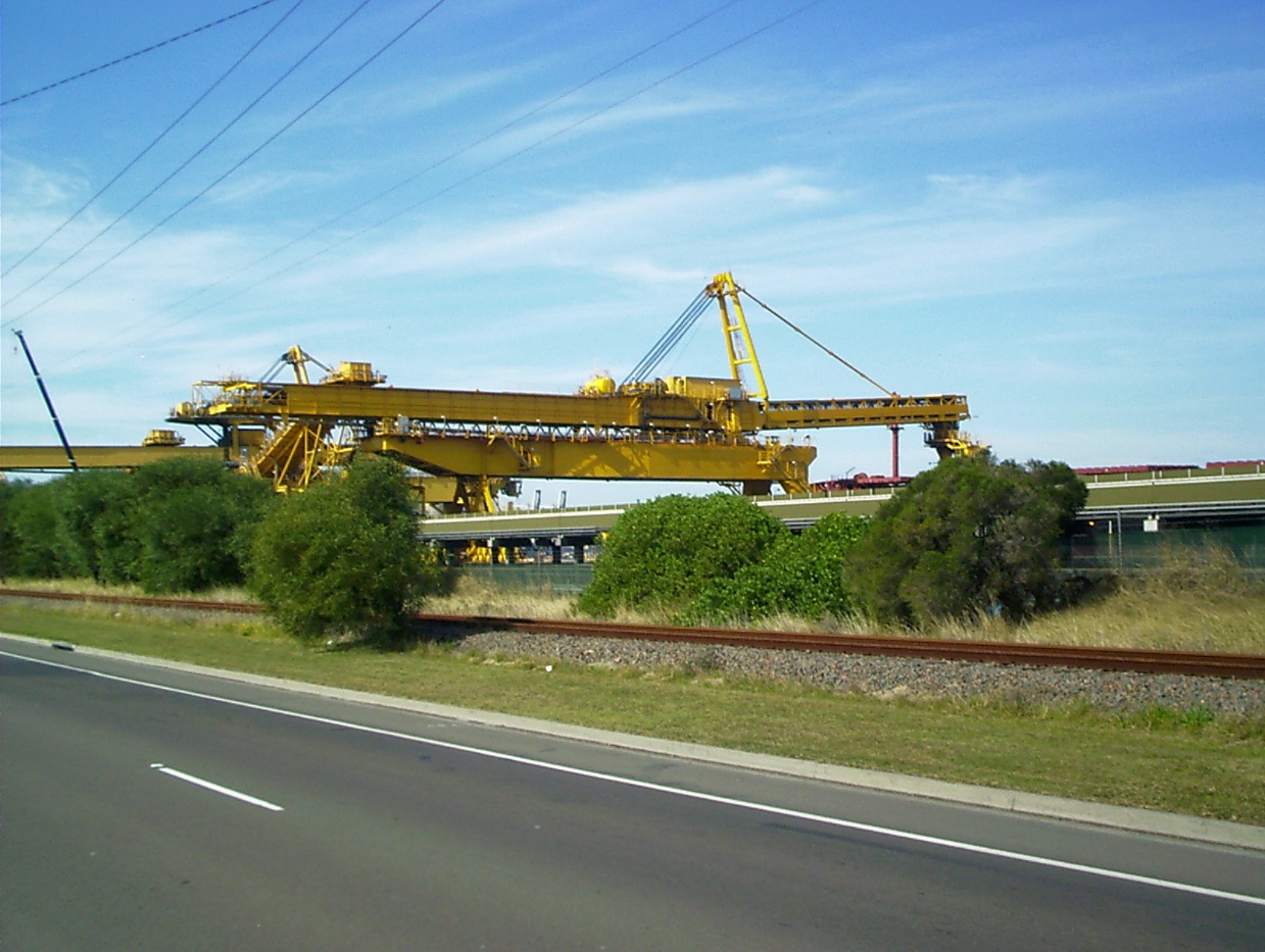 Long travelling bridge type shiploader with a large bridge structure spanning the rail-mounted loading system.